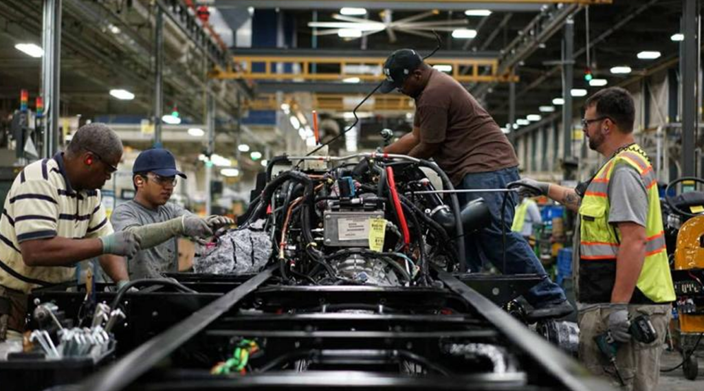 Men working on a truck in a factory, showcasing transportation industry trends for 2020.